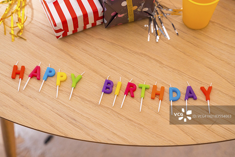 朋友生日派对上桌子上的生日快乐字母和礼物图片素材