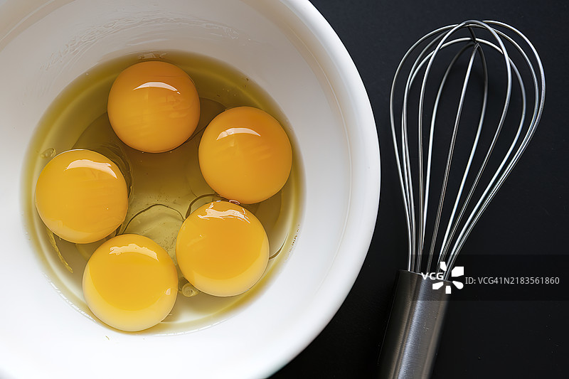 一个白色碗里装着几颗光滑蛋黄的生鸡蛋图片素材