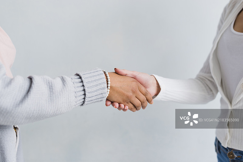 穿着浅色衣服的女性握手问候图片素材