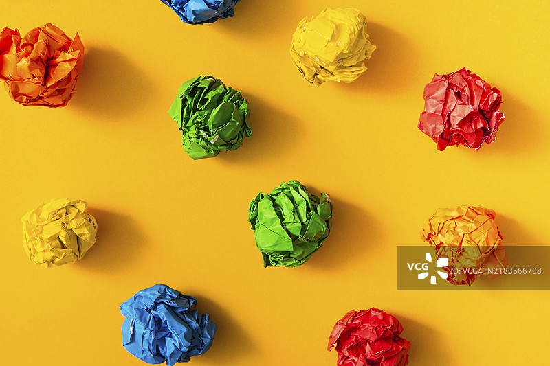五颜六色的皱纸球，背景为黄色图片素材