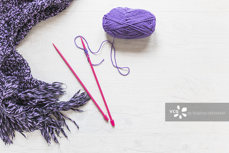 紫色毛线围巾与编织针，白色纹理背景图片素材