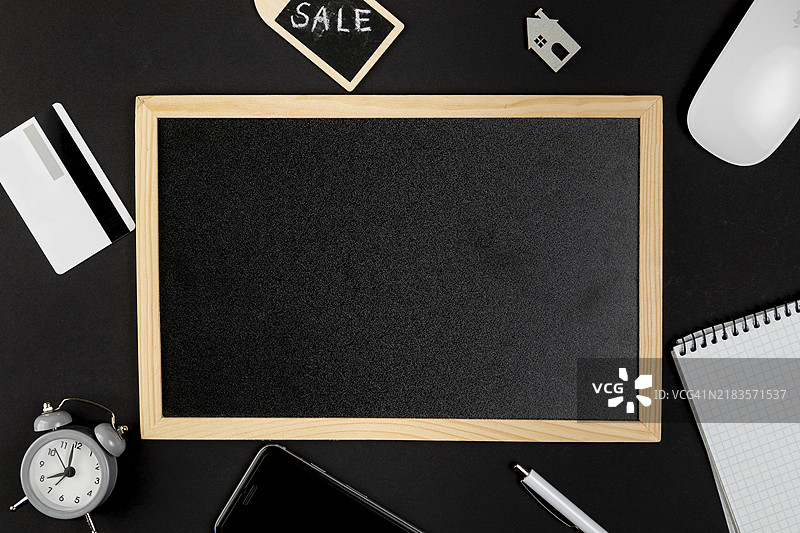 黑色白板周围摆放着办公用品图片素材