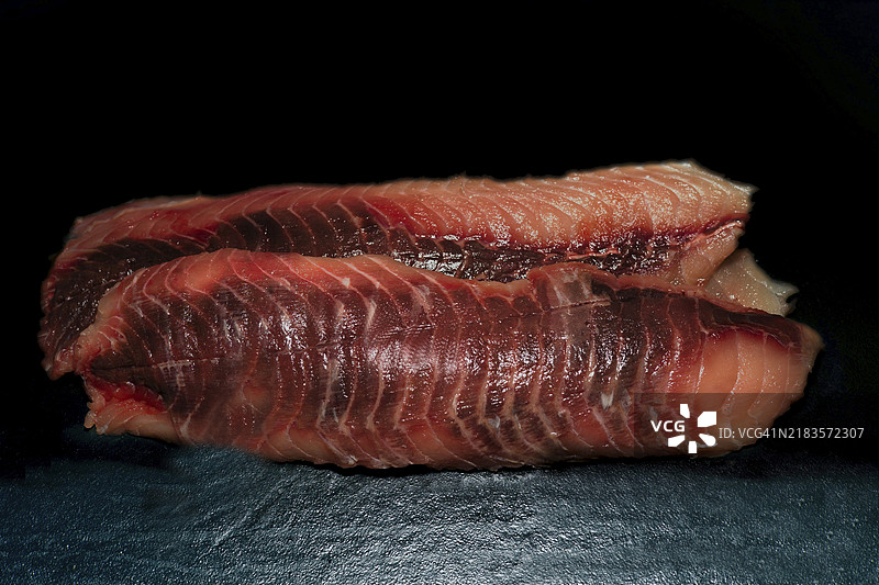 修整过的草鱼片（白鲢），来自Myramar的野生捕捞，黑色背景的美食摄影图片素材