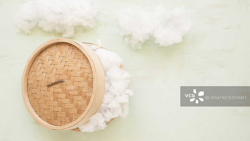 高角度视图的藤制蒸汽锅和白色棉布图片素材