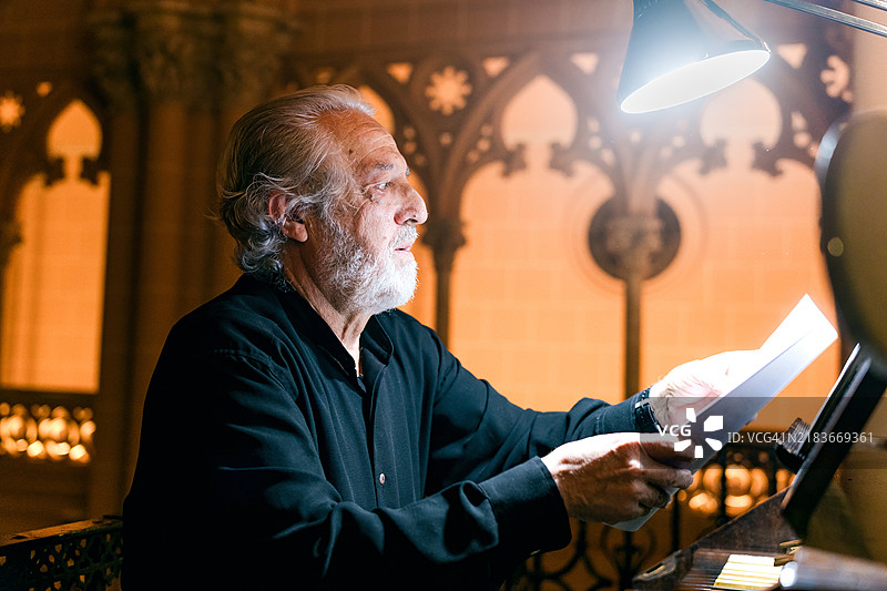 管风琴师在演出前准备乐谱并将其放在乐谱架上。图片素材