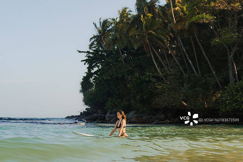 在斯里兰卡日落时分冲浪的女性图片素材