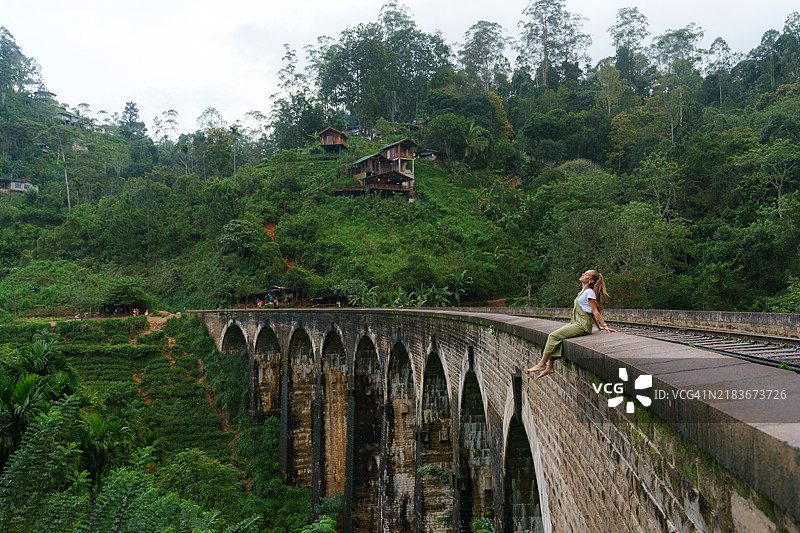 坐在斯里兰卡九拱桥上的女人图片素材