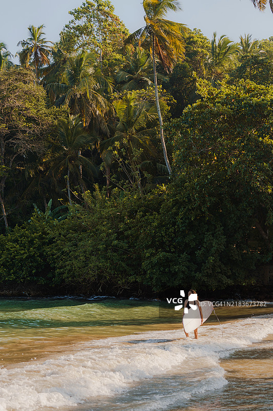 在斯里兰卡日落时分冲浪的女性图片素材