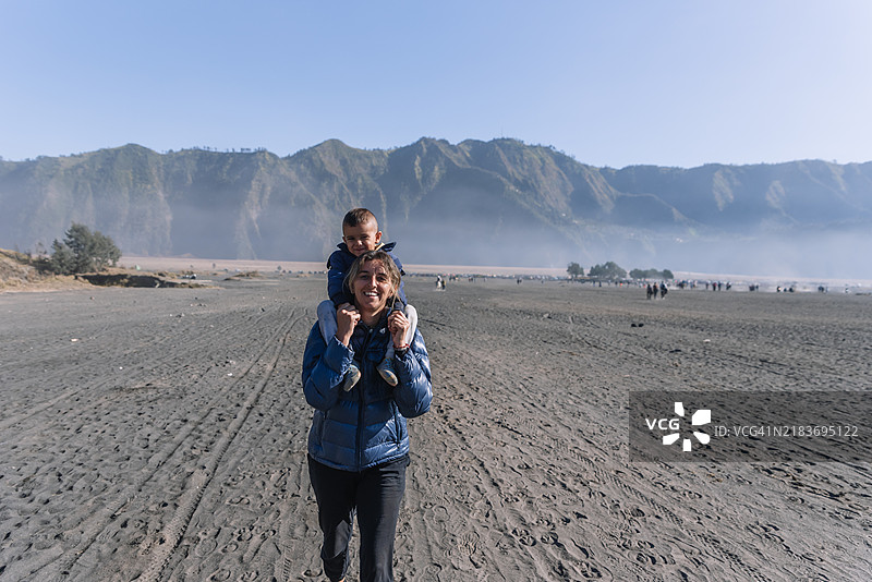 母亲和儿子快乐地走向布罗莫火山的火口。图片素材