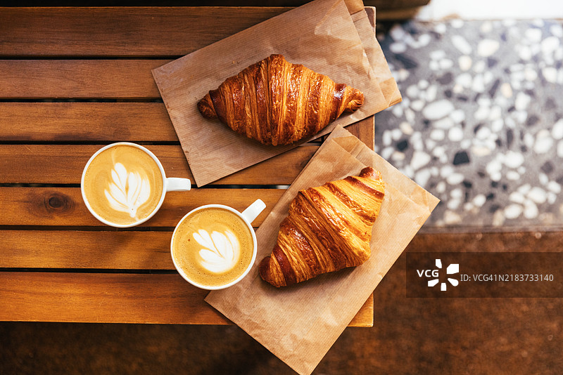 新鲜的可颂面包和咖啡在面包店供应，俯视角度图片素材