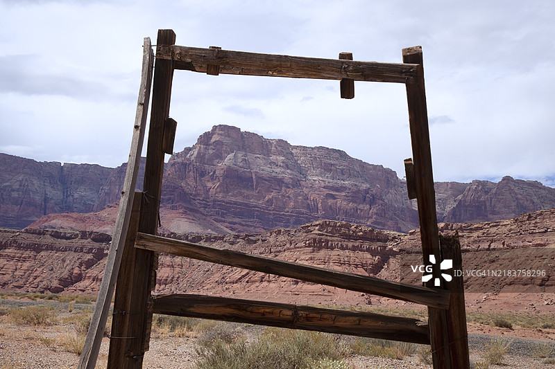 空的木制标牌结构框住了背景中的朱红色悬崖和天空。图片素材