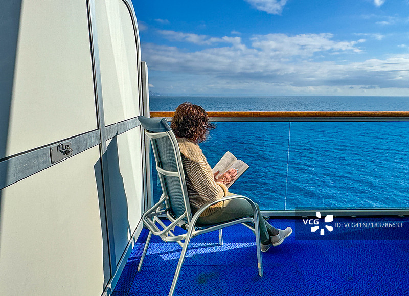 女人在游轮的阳台上阅读书籍图片素材