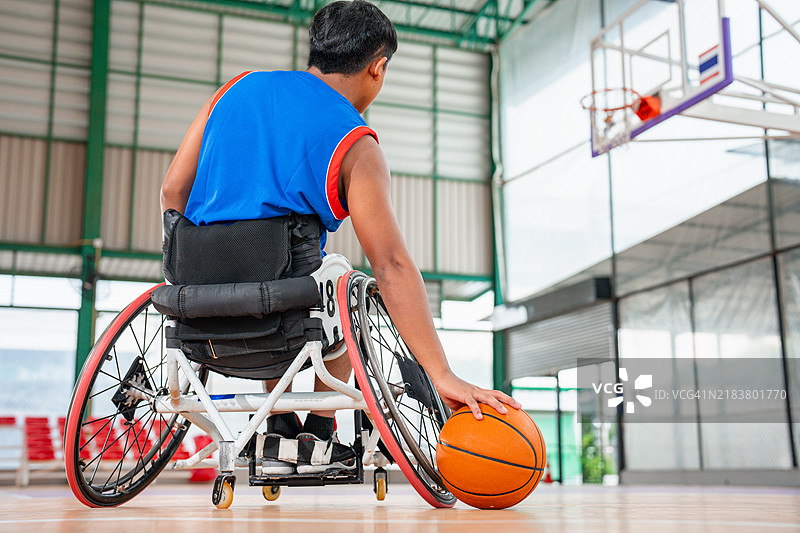 一名轮椅篮球运动员运球。图片素材