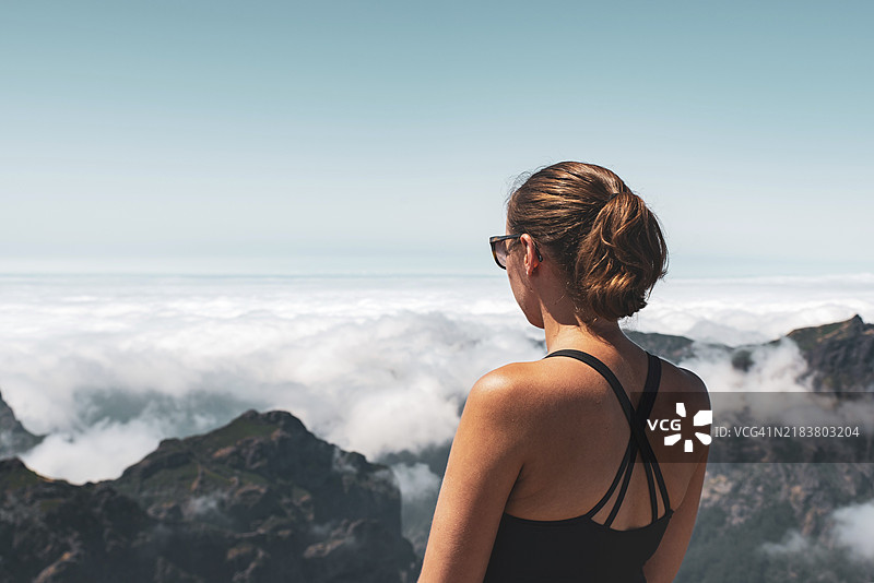 一位女性站在山顶俯瞰云层，宁静的氛围，皮库鲁伊沃，马德拉，葡萄牙，欧洲图片素材