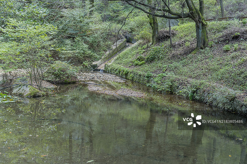 韩国山区荒野公园中的池塘，远端有一个小溢流口图片素材