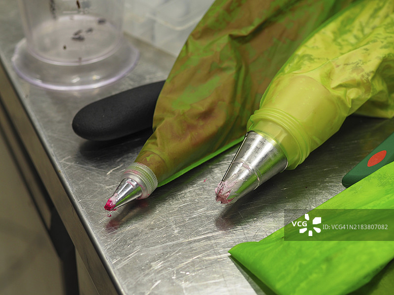 一个带金属尖的裱花袋放在厨房不锈钢表面上图片素材