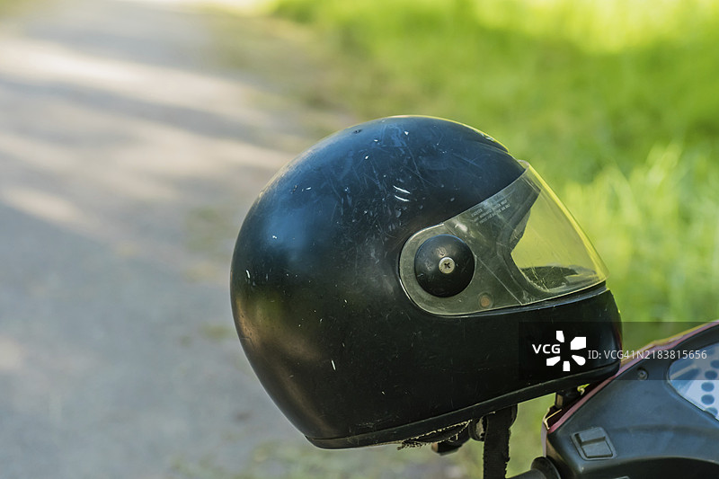 黑色摩托车头盔放在滑板车的把手上，背景模糊，地点在韩国图片素材