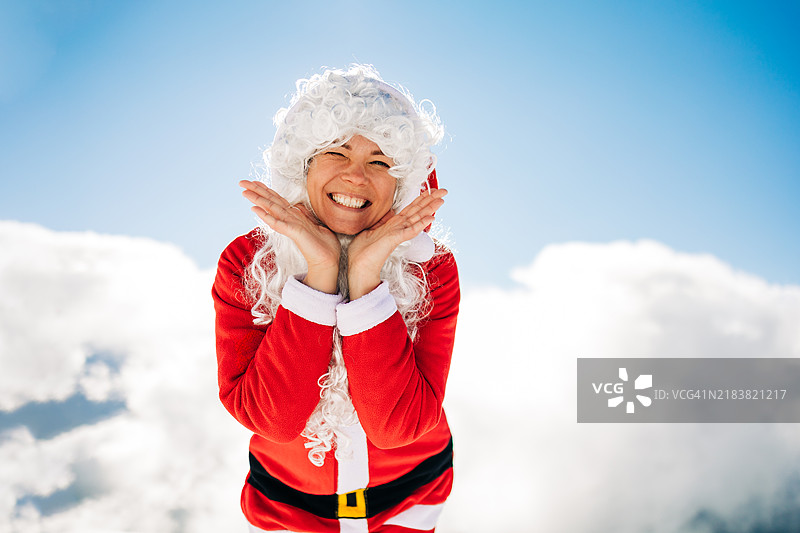 快乐的女性圣诞老人微笑着，置身于雪白的冬季仙境中。图片素材