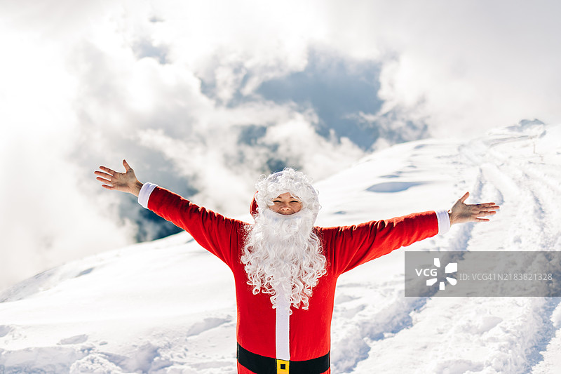 快乐的女性圣诞老人微笑着，置身于雪白的冬季仙境中。图片素材