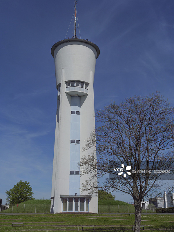 一座孤独的塔楼，背景是晴朗的蓝天，前景是一棵光秃的树，德国特里尔图片素材