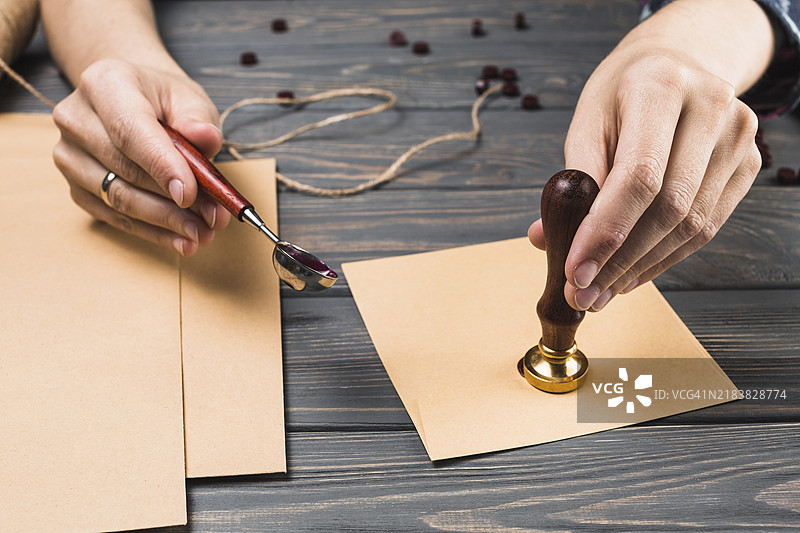 女人的手在封口信封并贴上邮票图片素材