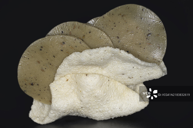 生米和炸米饼，香料饼，黑色背景下的食物摄影圆形展示图片素材