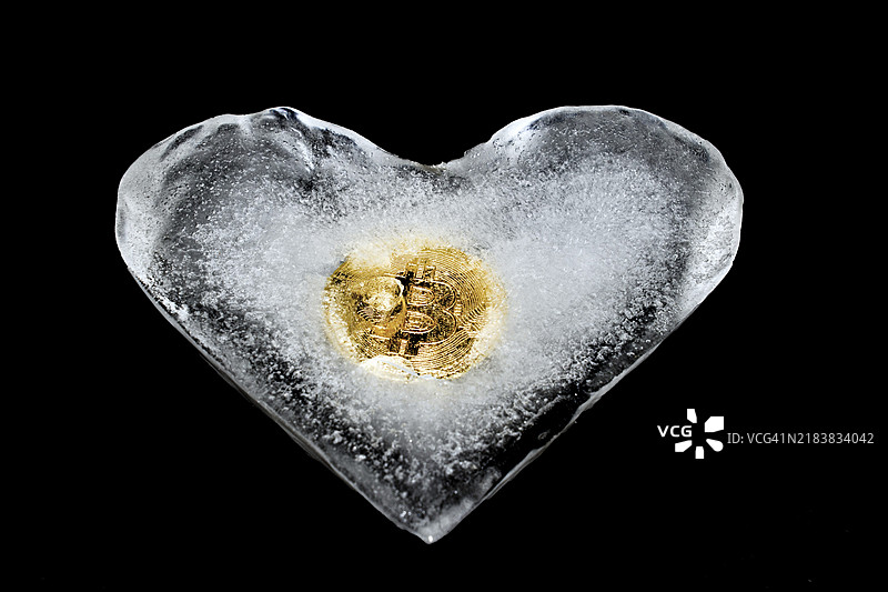 心形的比特币被冻结，黑色背景下的工作室摄影图片素材