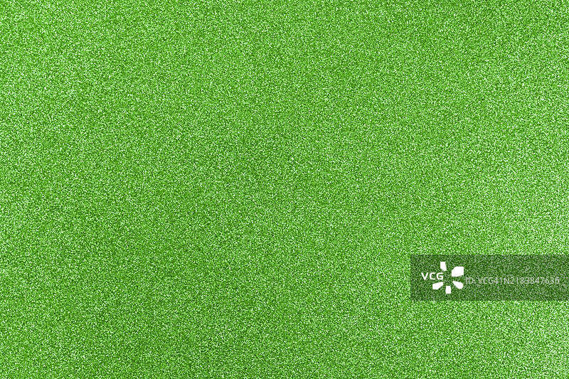 绿色闪亮背景，带有闪烁的颗粒，质感十足。新年和圣诞节的节日背景。图片素材