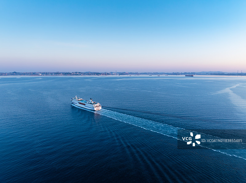 日出时分，船只进入港口的鸟瞰图图片素材