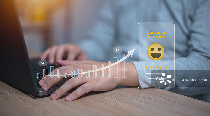 正在使用笔记本电脑的人，图形覆盖显示客户满意度评分，带有向上趋势的箭头，表示积极反馈或满意度的提升。图片素材
