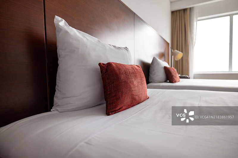 酒店房间内舒适且整理好的床铺图片素材