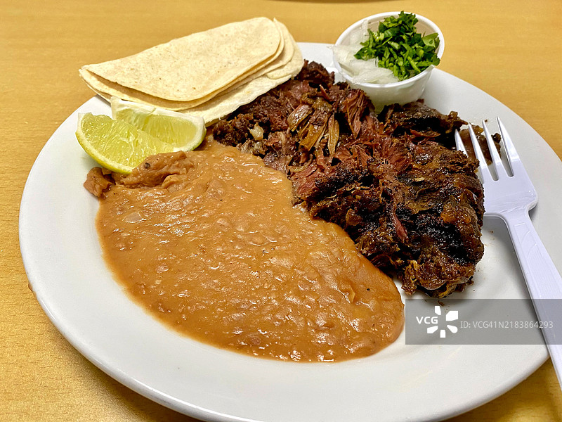 新鲜的巴巴科阿肉和豆子，配以玉米饼和青柠图片素材