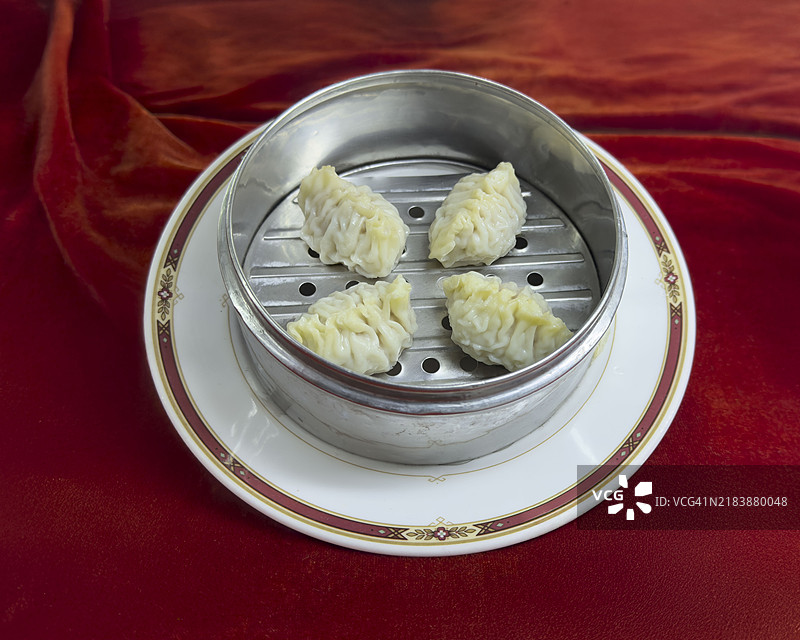 红色天鹅绒背景下的鲨鱼鳍蒸饺图片素材