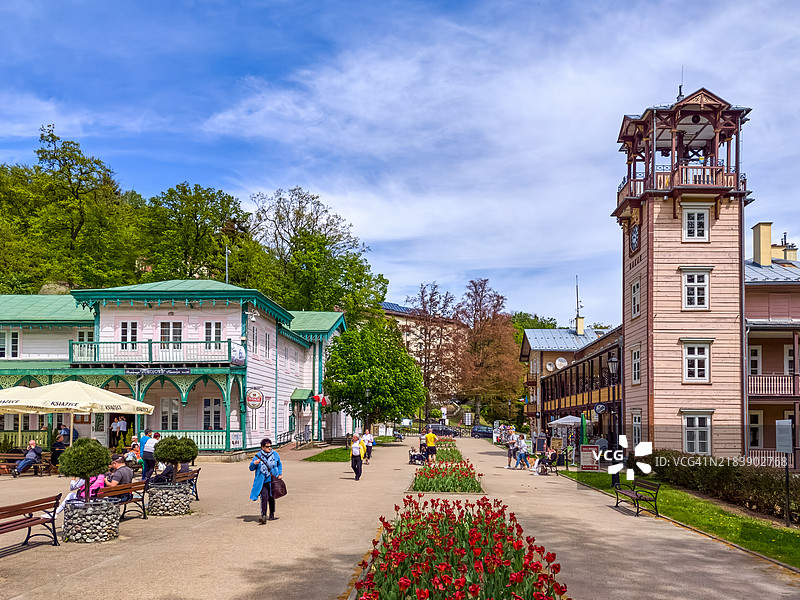 温泉小镇的长廊，五彩斑斓的郁金香与传统建筑相映成趣。图片素材