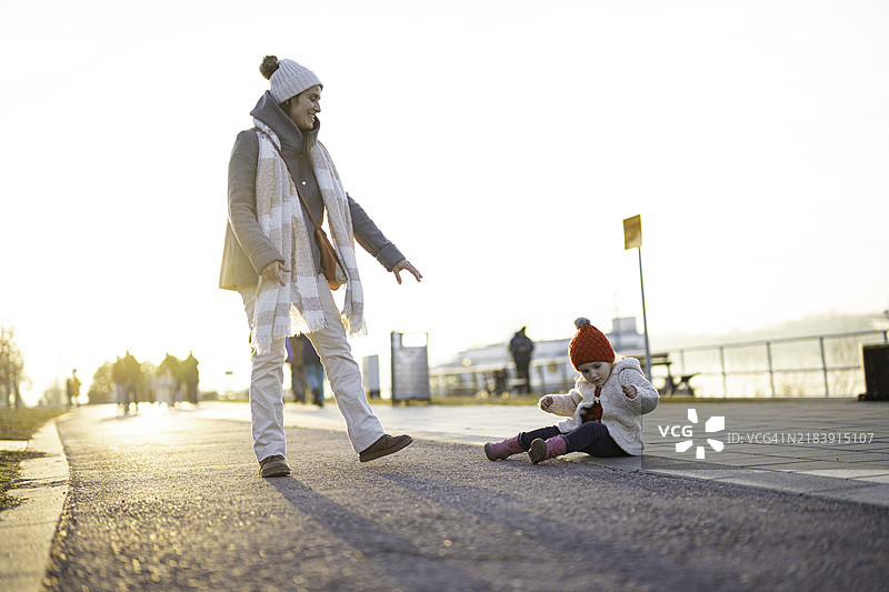 城市户外生活方式。妈妈和孩子在城市散步。图片素材
