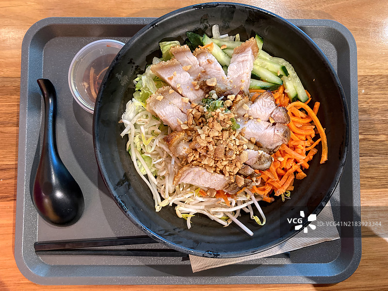 猪肉肚包（bún）温暖的米粉沙拉，配有胡萝卜丝、生菜、黄瓜、花生、豆芽、香菜和鱼露酱。图片素材