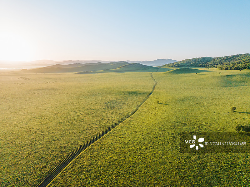 蜿蜒的道路穿过绿色草原图片素材