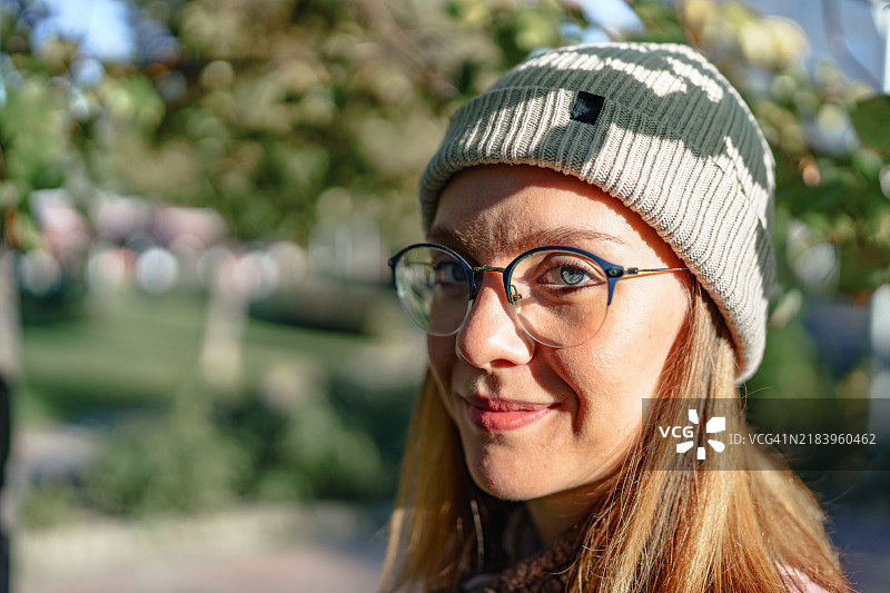 戴着贝雷帽和眼镜的蓝眼睛女性肖像。图片素材