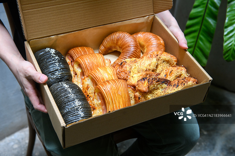 手握一盒糕点作为礼物图片素材