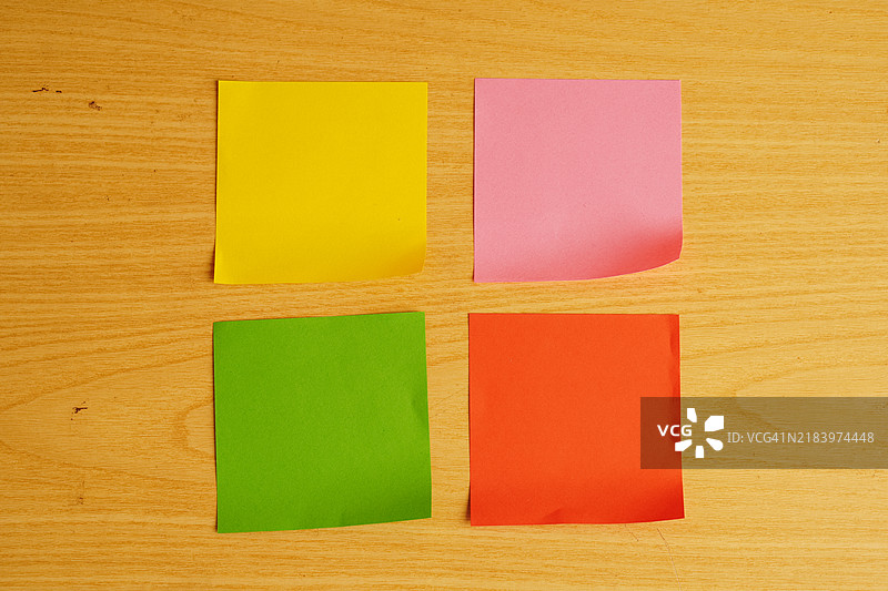 多彩的粘性便签纸放在木质背景上图片素材