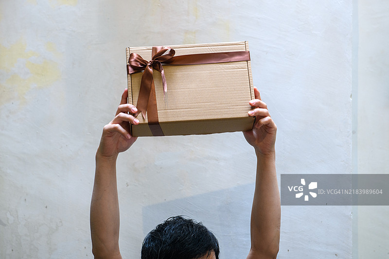 一个无法辨认的男性手持礼品盒图片素材