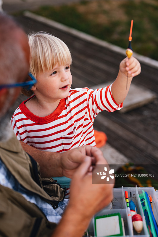 祖父和孙子享受宁静的钓鱼之旅图片素材