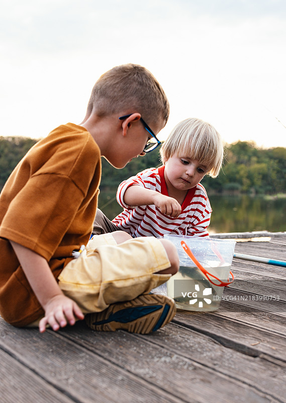 孩子们在湖边兴奋地探索钓鱼冒险图片素材