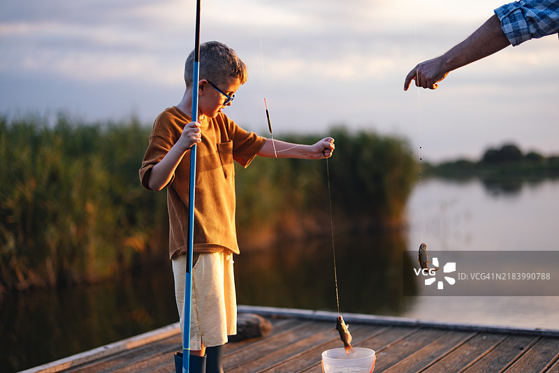 祖父和孙子一起享受宁静的钓鱼日图片素材