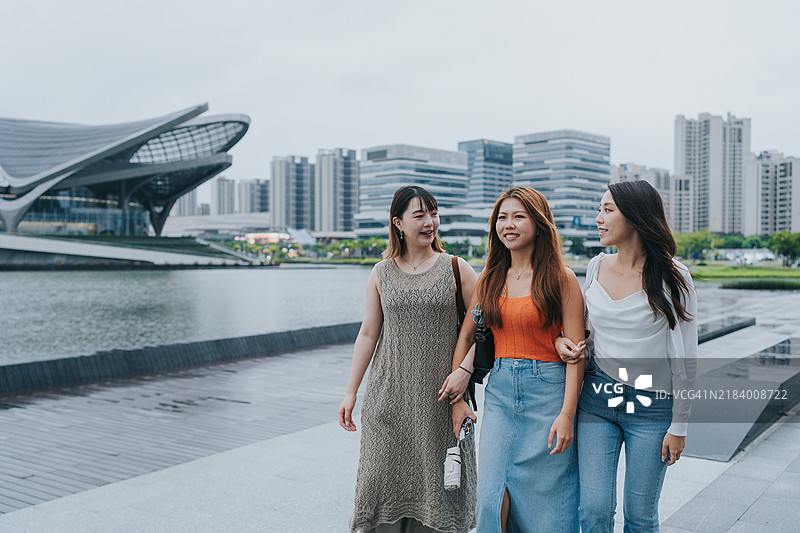 快乐的Z世代女孩在中国大湾区珠海旅行，雨天经过珠海金湾市民艺术中心。图片素材