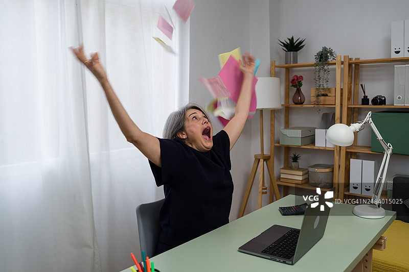 兴奋的资深自由职业者在空中抛洒文件庆祝成功图片素材