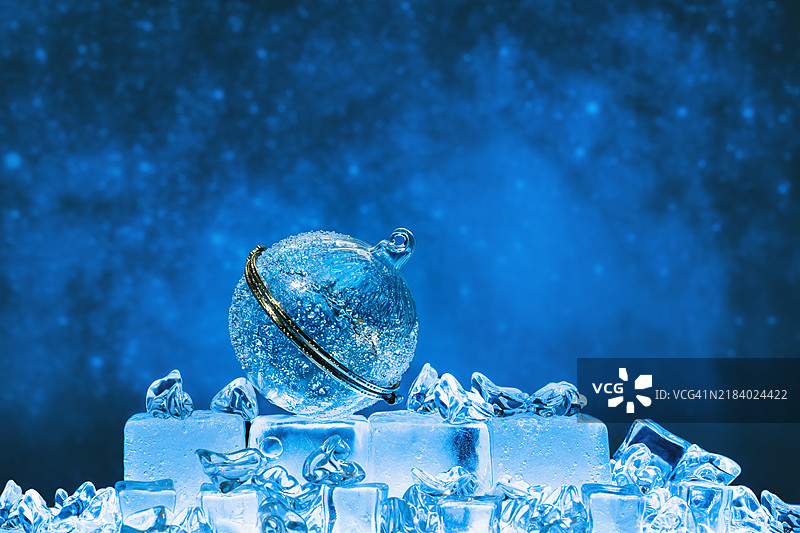 冰霜玻璃圣诞球在冰面上与深蓝色天空相映衬图片素材