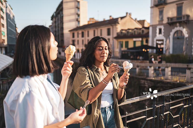 两个朋友在意大利米兰的街头享受冰淇淋图片素材
