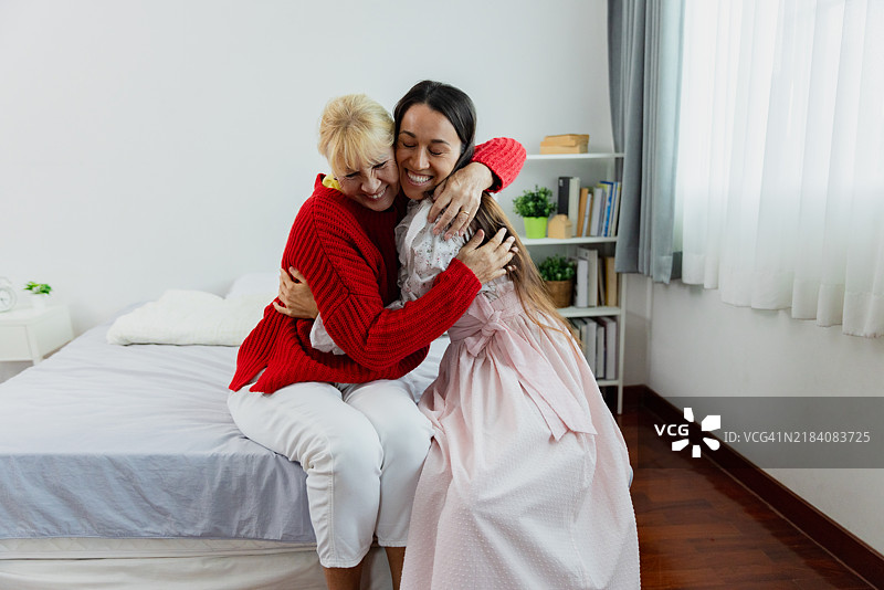 阳光明媚的下午，母女在温馨的卧室里欢快重聚图片素材