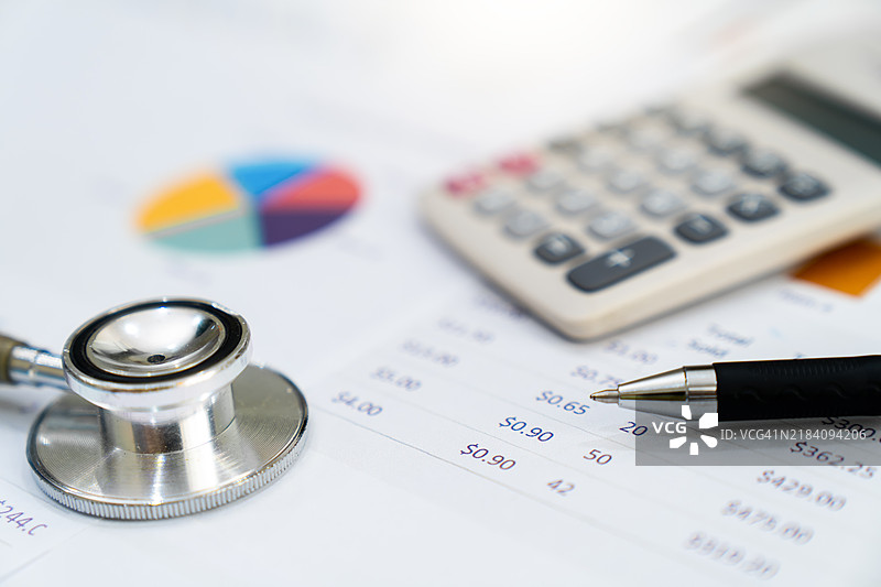 听诊器和计算器放在文件上。图片素材